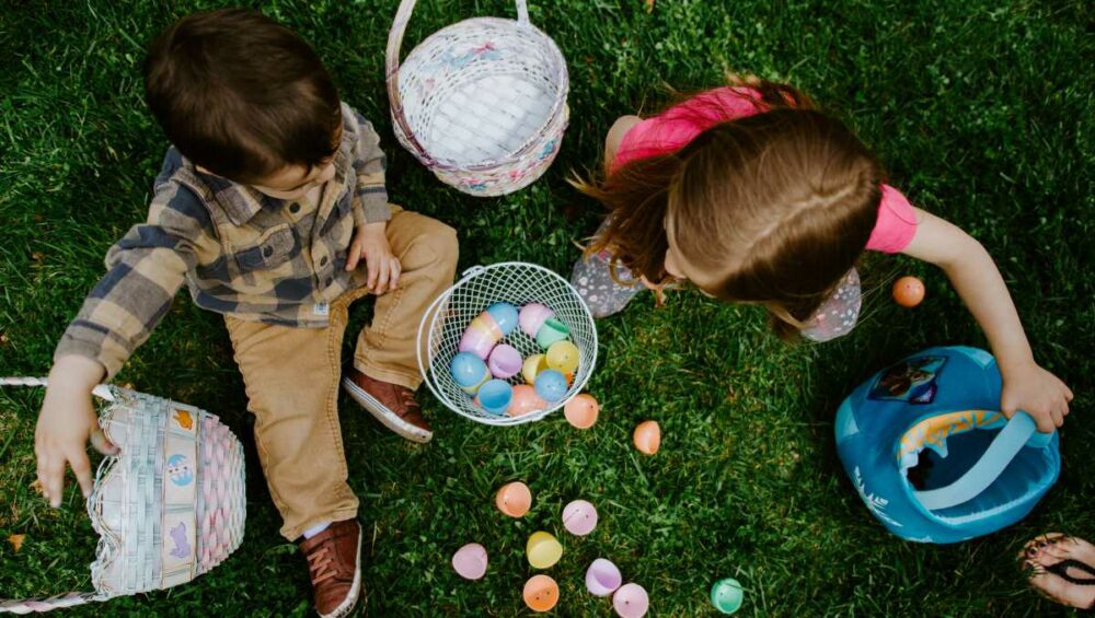 Enfants faisant la chasse aux oeufs dans un jardin